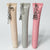 Three lip balm tubes with charms against a gray background