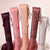 Set of Alei Beauty lip glosses on a light pink background