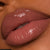 Mocha lipgloss with vitamin E on black model 
