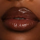 Brown peptide lipgloss paired with a dark brown lipliner on black model