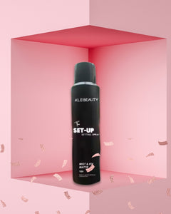 Black spray bottle labeled 'ALEBEAUTY SET-UP' on a pink background