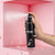 Black spray bottle labeled 'ALEBEAUTY SET-UP' on a pink background